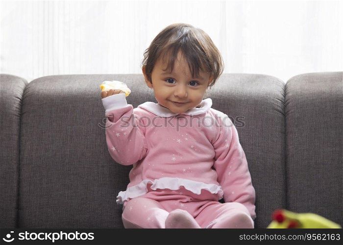 Cute baby with toy in hand looking at camera
