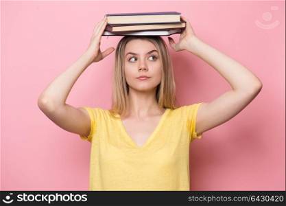 Cute beautiful woman with books having fun during reading and study process.