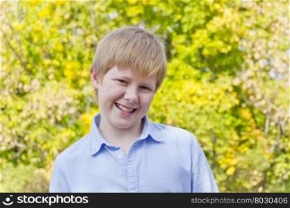 Cute blond boy in autumn yellow forest