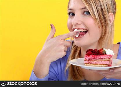 Cute blond eating a cake.