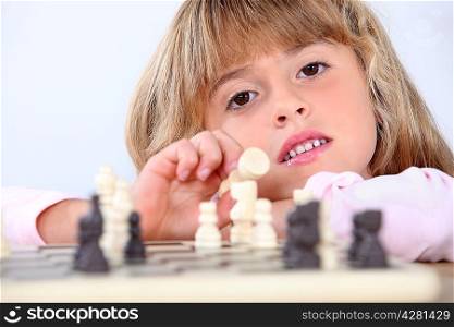 Cute blond girl playing chess