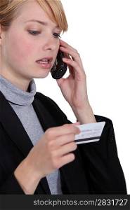 cute blonde businesswoman on the phone holding credit card