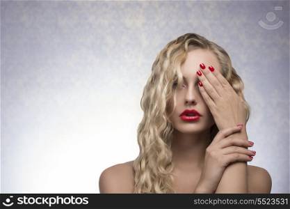 cute blonde female with long wavy hair, red lips and nail polish