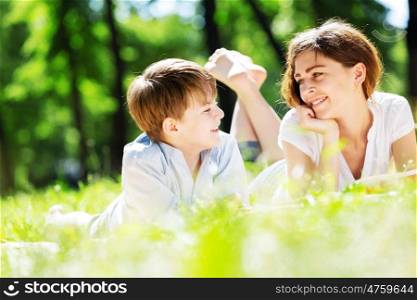 Cute boy and young woman in summer park. Weekend in park