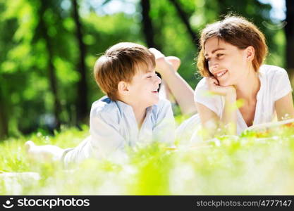 Cute boy and young woman in summer park. Weekend in park