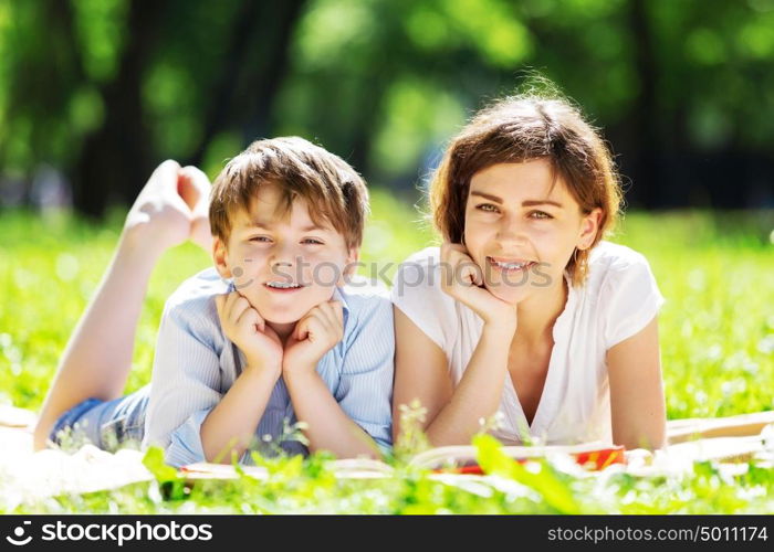 Cute boy and young woman in summer park. Weekend in park