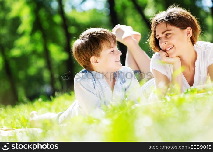 Cute boy and young woman in summer park. Weekend in park