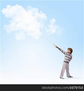 Cute boy dreaming. Image of little cute boy catching clouds in sky
