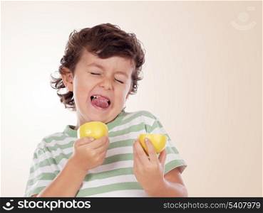 Cute boy eating lemon isolated on a orange background