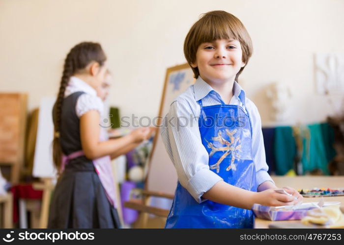 Cute boy painting. Image of little cute boy painting pictures at kindergarten