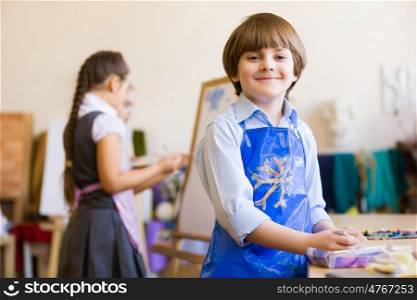 Cute boy painting. Image of little cute boy painting pictures at kindergarten