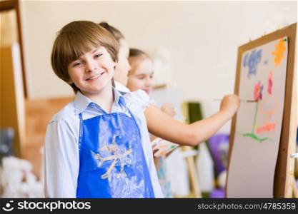 Cute boy painting. Image of little cute boy painting pictures at kindergarten