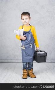 cute boy standing with tool box paper rolls