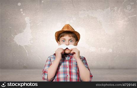 Cute boy wearing shirt hat and mustache. Kid having fun