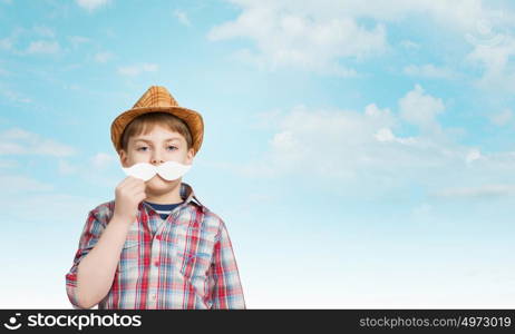 Cute boy wearing shirt hat and mustache. Kid having fun