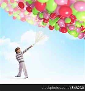 Cute boy with balloons. Image of little cute boy holding bunch of colorful balloons