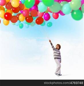 Cute boy with balloons. Image of little cute boy holding bunch of colorful balloons