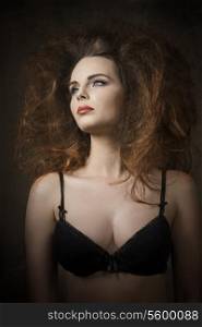 cute brunette girl posing in fashion shoot with volume fashionable hair-style, red lipstick and black bra