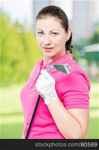cute brunette has a hobby playing golf, portrait on a background of golf courses