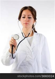 cute brunette in white medical gown and a stethoscope focus on the stethoscope
