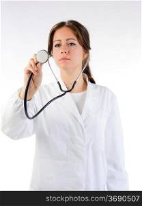 cute brunette in white medical gown and a stethoscope focus on the stethoscope