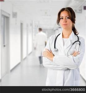 cute brunette in white medical gown and a stethoscope in an hospital