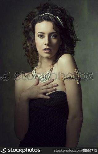 cute brunette woman posing in fashion portrait with curly hair-style, creative accessories and sexy dress &#xA;