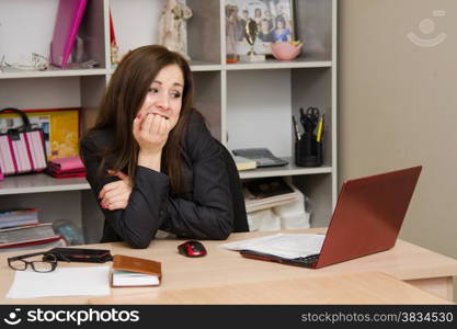 Cute business woman in the office at the computer