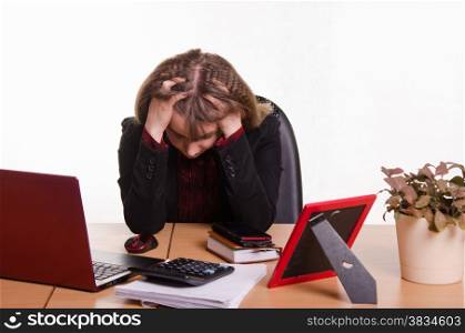 Cute business woman in the office at the computer. girl behind office desk grabbed head in his hands