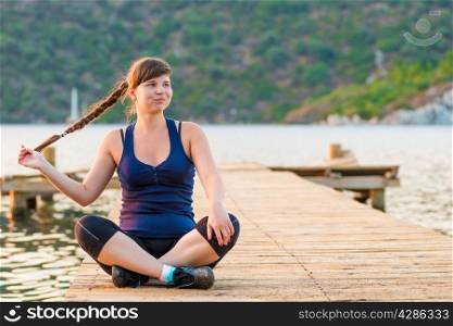 cute charming young girl in sportswear on a pier