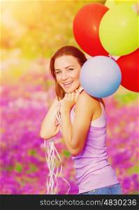 Cute cheerful female having fun with bunch of colorful balloons in spring garden, birthday celebration, happiness concept&#xA;