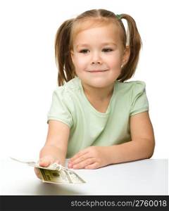 Cute cheerful little girl with paper money - dollars, isolated over white