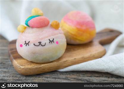 Cute Chinese Pastry or moon cake stuffed with salted egg yolk on wood plate