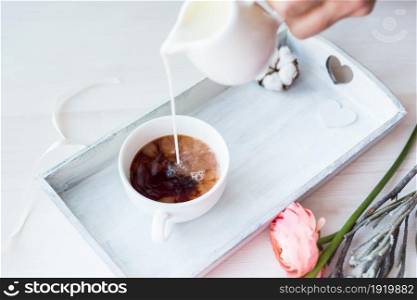 Cute close-up photo of a coffee cup on a tray with flowers.. Cute vintage mock up on wooden background. Flat lay top view.