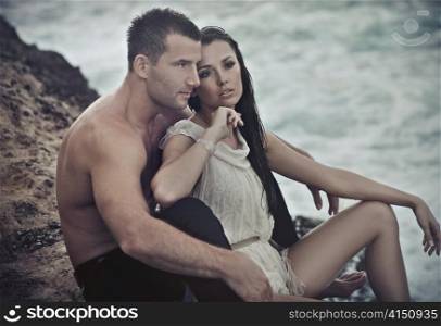 Cute couple sitting on rocks