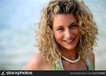 Cute curly-haired blond stood by the ocean