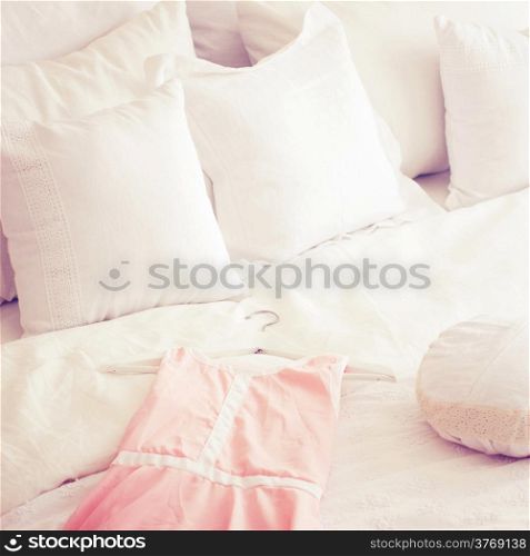 Cute dress and pillows on bed with retro filter effect