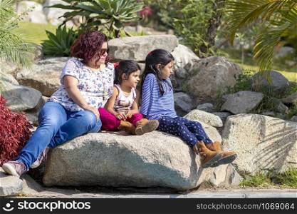 Cute family of mother and daughters in the garden