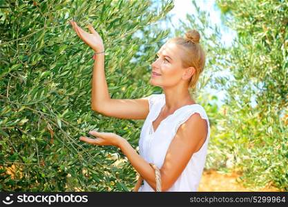 Cute farmer girl enjoying harvest of olives, walking in the garden in bright sunny autumn day, cultivation of organic food, healthy lifestyle