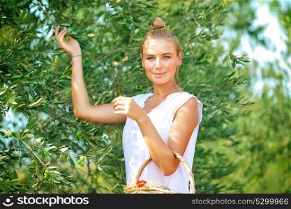 Cute farmer girl enjoying harvest of olives, walking in the garden on bright sunny autumn day, cultivation of organic food, healthy lifestyle