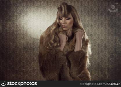 cute fashion portrait of attractive young girl posing with long creative hairdo, elegant make-up and wearing winter warm fur