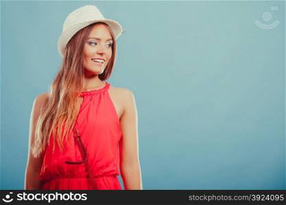 Cute fashion woman in hat and red shirt. Portrait.. Portrait of cute attractive young woman girl in red shirt and straw hat in studio on blue. Summer female fashion vogue.