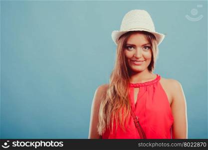 Cute fashion woman in hat and red shirt. Portrait.. Portrait of cute attractive young woman girl in red shirt and straw hat in studio on blue. Summer female fashion vogue.