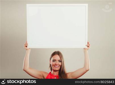 Cute fashion woman with blank empty white banner.. Cute attractive young woman girl in red shirt in studio with blank empty white copy space banner. Summer female fashion vogue and advertisement.