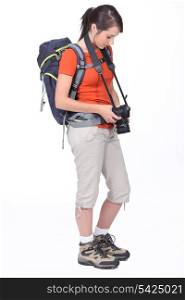 cute female hiker with camera isolated on white
