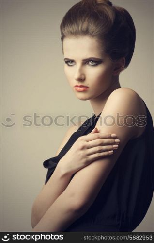cute female with perfect fashion style posing with creative hair-style and make-up, wearing elegant black dress