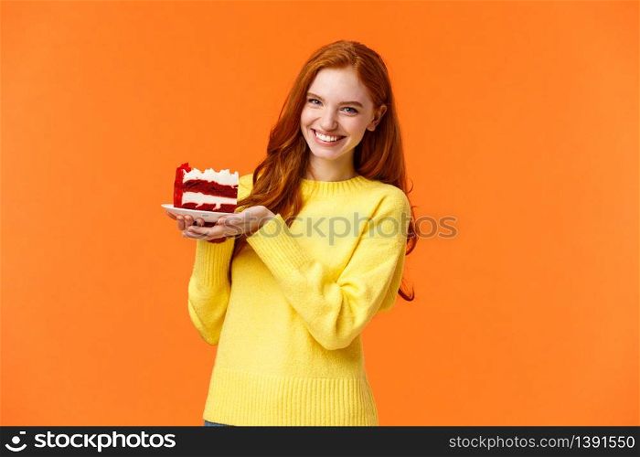 Cute friendly redhead woman holding tasty home-made piece cake and smiling, share bite, treat friends, grinning as celebrating birthday or like eating sweet delicious desserts, orange background.. Cute friendly redhead woman holding tasty home-made piece cake and smiling, share bite, treat friends, grinning as celebrating birthday or like eating sweet delicious desserts, orange background