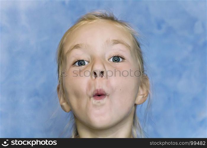 Cute fun girl with blond hair on blue background