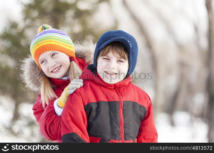 Cute girl and boy having fun in winter park. Winter activities