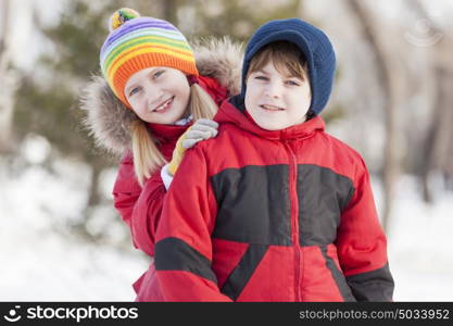 Cute girl and boy having fun in winter park. Winter activities